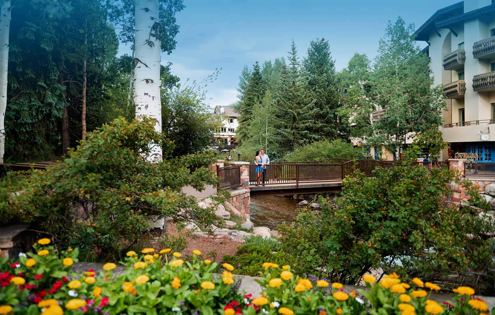 Couple in Vail Village on Bridge in summer. Vail Lodging